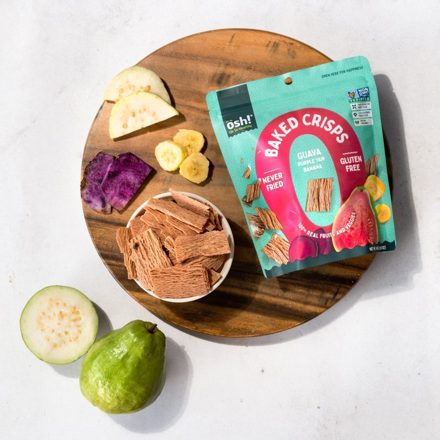 Guava crisps in a bowl on a wooden board with sliced guava, purple yam and banana