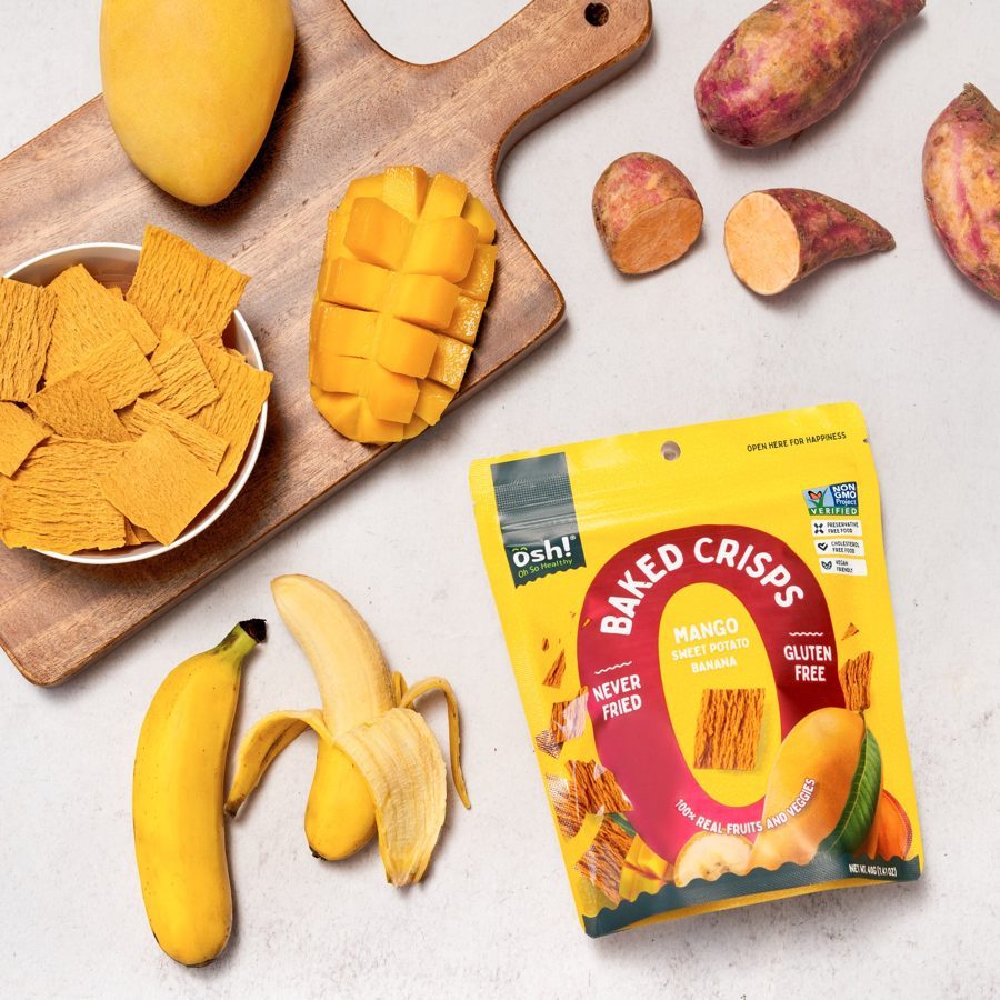 Mango crisps in a bowl with fresh mango, bananas and sweet potato beside a Mango pack
